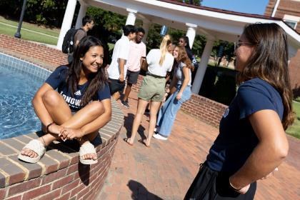 Students sit at the fountain and talk