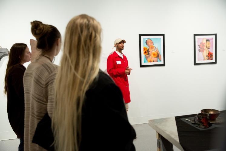 a student talks about their art work at research day