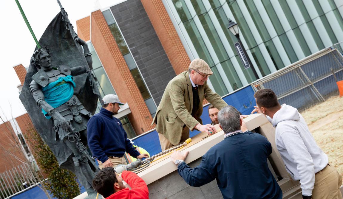 Sculptor Alexander Stoddart assists with the installation