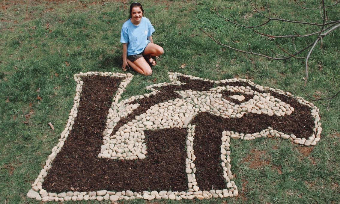 Rachel Arrington ’22 with her rock sculpture of the Lancer logo