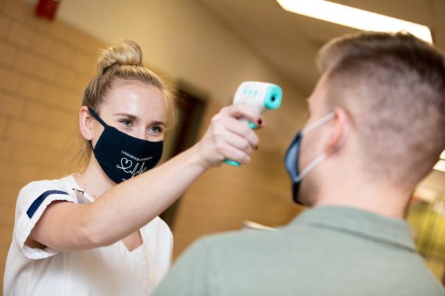 Nursing student takes someone's temperature