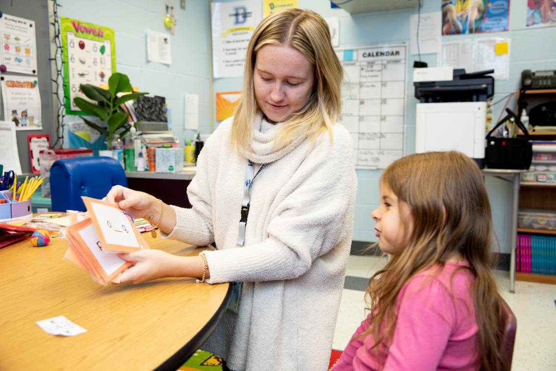 Student teacher working with a child using flashcards