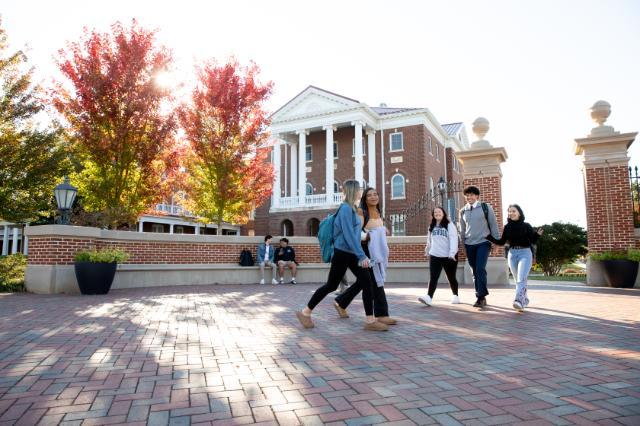 Students walking in front of The Gate at Longwood on the way to class